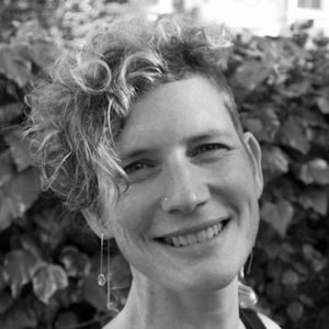 A woman with curly hair and long earrings.