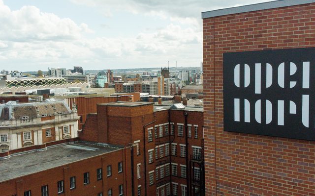 A building with the Opera North logo on it. Central Leeds is in the background.