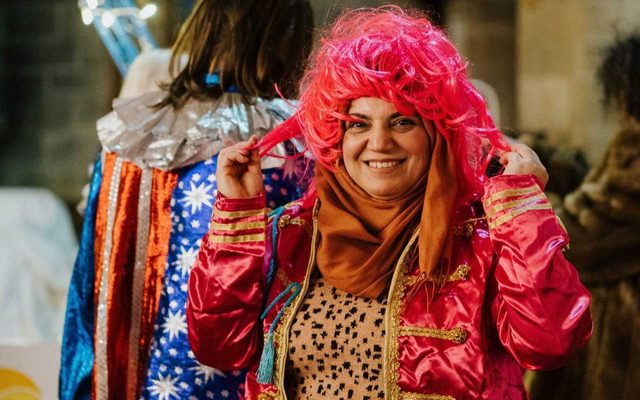 Lady in bright clothes tries on pink wig