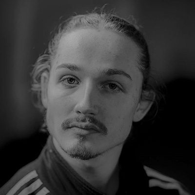 A man with a moustache and goatee, with his hair tied back.