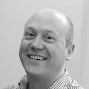 A bald man wearing a chequered shirt.