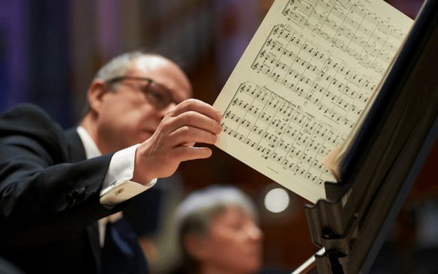 A photo of a violinist turning the page of some music.