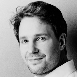A man with short fair hair wearing a shirt.