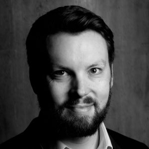 A man with a beard smiling.