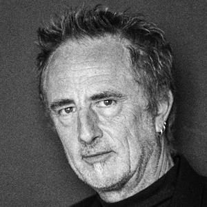 A man with short hair and a black shirt.