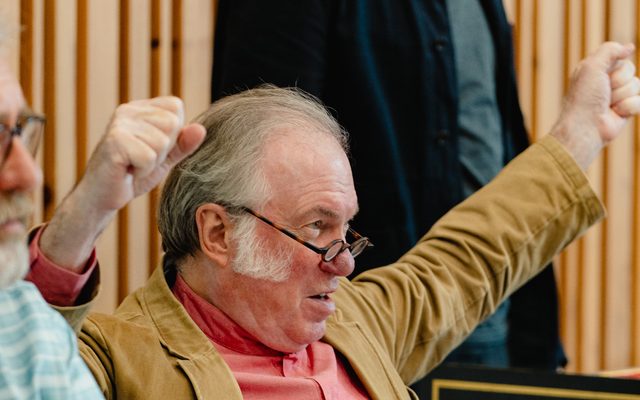 Opera director Sir David Pountney with his arms in the air in rehearsal for Masque of Might