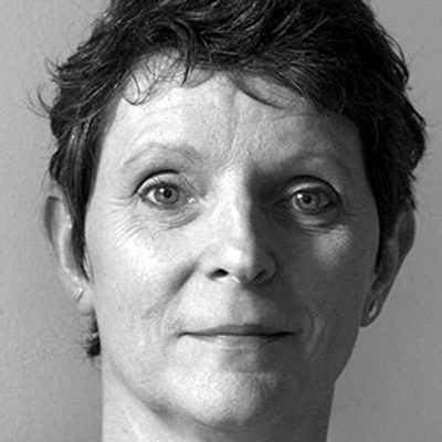 A woman with short dark hair and stuff earrings.