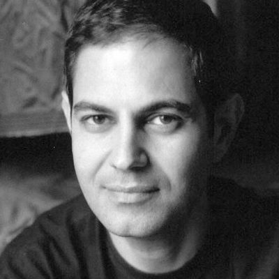 A man with short dark hair in a t-shirt.