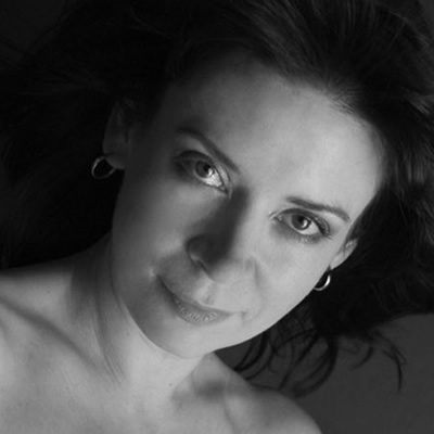 A woman with dark hair wearing earrings.