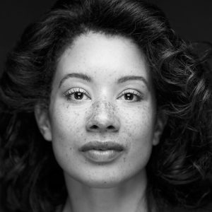 A woman with dark hair and freckles.