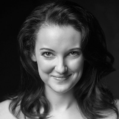 A smiling woman with should-length dark hair.