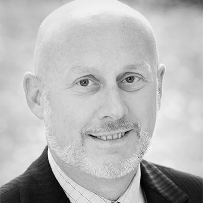 A bald man in a suit and jacket.