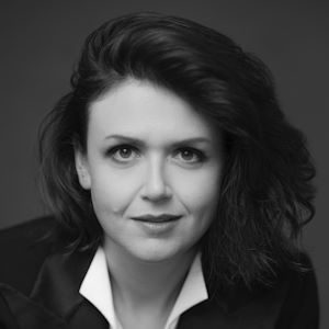 A close-up photo of a woman with dark hair looking at the camera