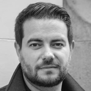 A man with short dark hair and a neat beard.