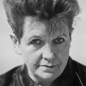 A woman with short hair wearing a leather jacket.