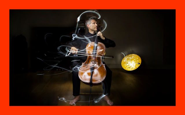 A man playing a cello while surrounded by late.