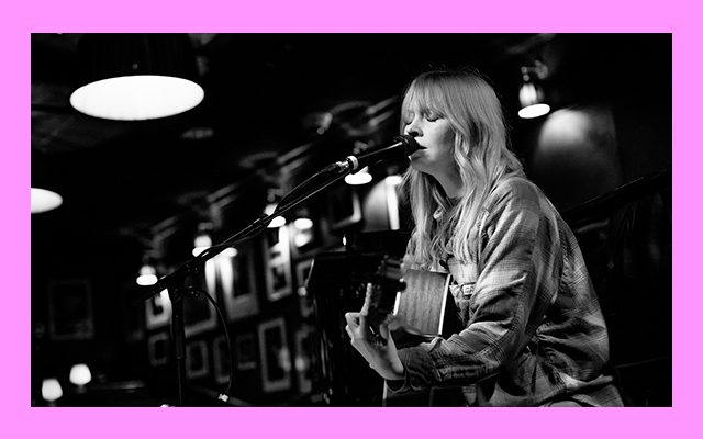 Black and white photo of a woman singing into a microphone