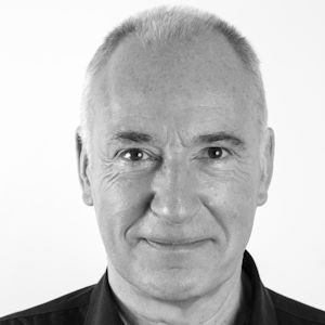 A man with short hair and a black shirt.