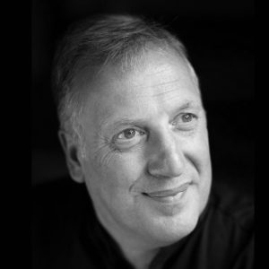A man with short hair wearing a black shirt.