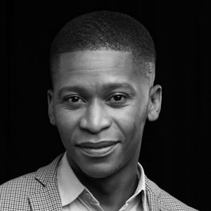 A man with short hair wearing a shirt and blazer.