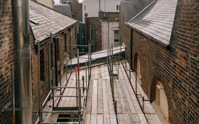 Scaffolding with rooftops either side