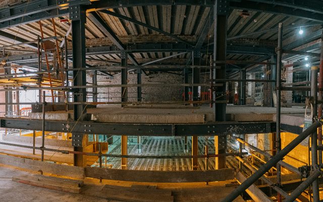 Building works with scaffolding and a man wearing hi-vis