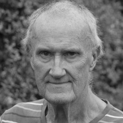 An older man with short hair wearing a t-shirt.
