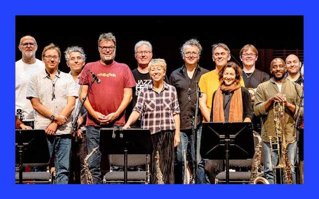 A group of musicians stood on a stage.