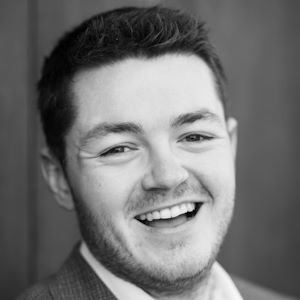A man in a suit smiling.