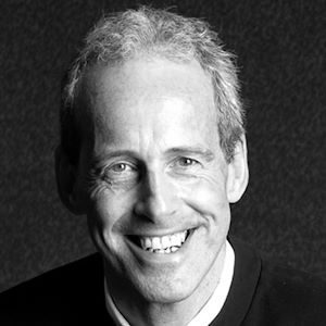A smiling man wearing a shirt.