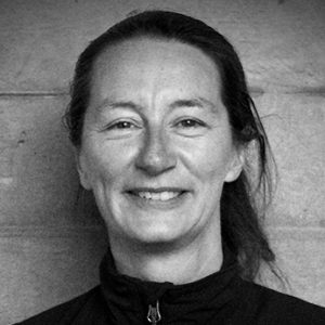 A woman wearing a fleece with her hair tied in a pony tail.