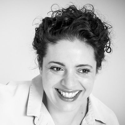 A smiling woman with short curly hair.
