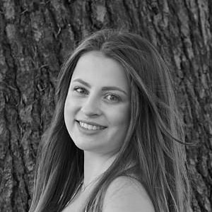 A woman with long hair stood in front of a tree.