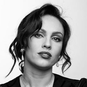 A woman with wavy hair and earrings.