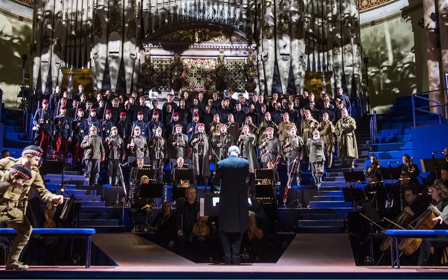 Alex Banfield as Jonathan Dale, Christopher Nairne as William Dale and Rupert Charlesworth as Nikolaus Sprink with the Chorus of Opera North, Students of the Royal Northern College of Music, Opera North Youth Chorus and the Soldiers’ Chorus – Community Singers © Tristram Kenton