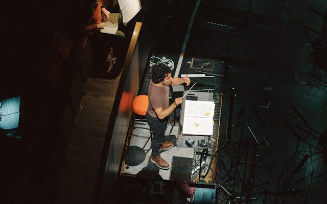 A man standing in front of a mixer in an orchestra pit