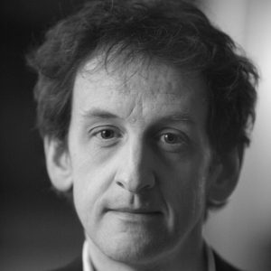 A man with dark hair wearing a suit.