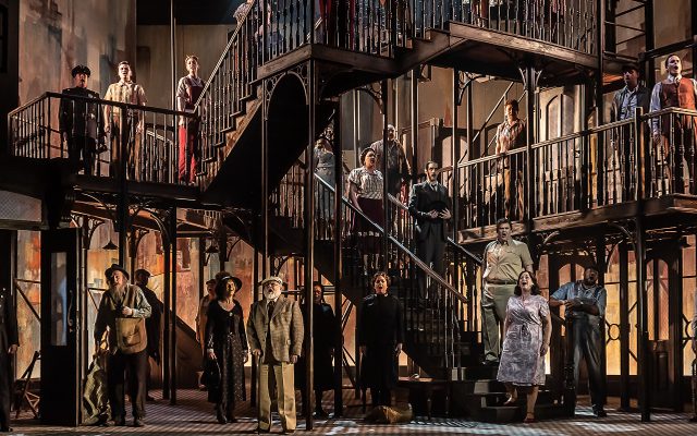The cast of Street Scene crowd onto multiple levels of the 1940s tenement building set