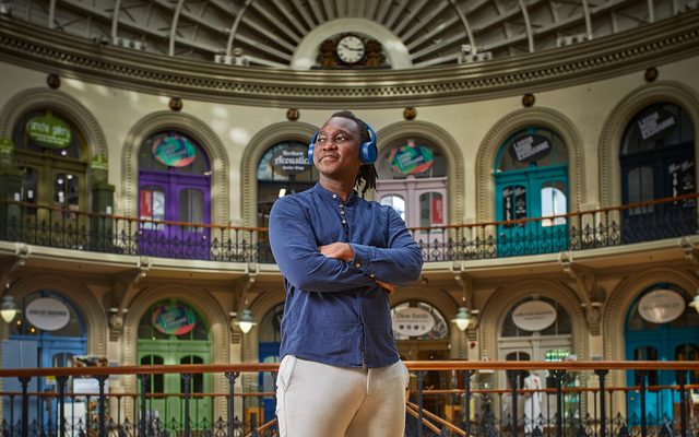 Musician, Abel Selaocoe stands with earphones on in the Corn Exchange