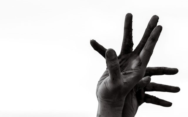 Two hands held against the sky.