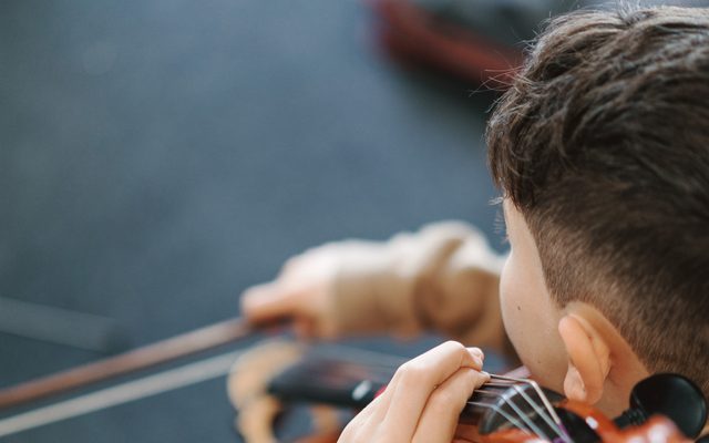 The back of a child playing the violin