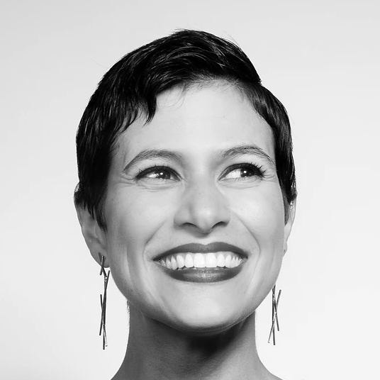 Elena-Urioste A smiling woman wearing large earrings.
