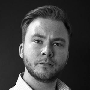 A man with a shirt beard and slicked back hair in a shirt.