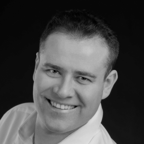 A man in a white shirt smiling.