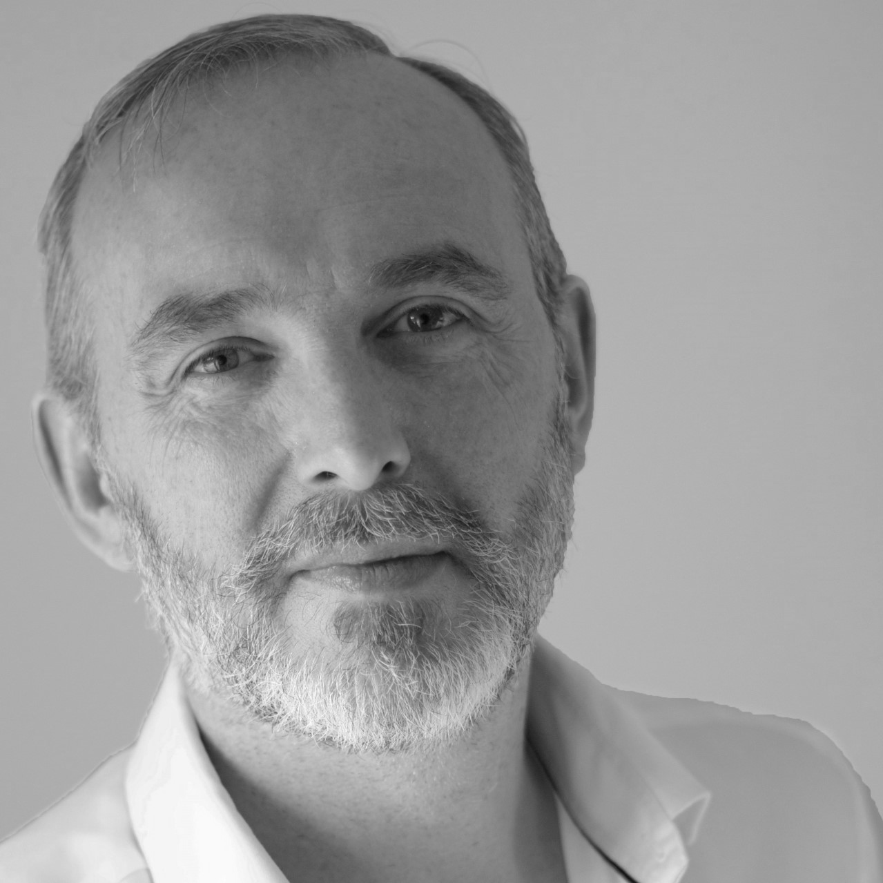 A man with a short beard wearing a white shirt.